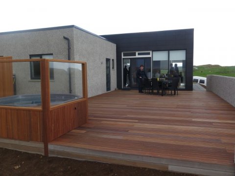 Þorgerður á pallinum fyrir aftan húsið